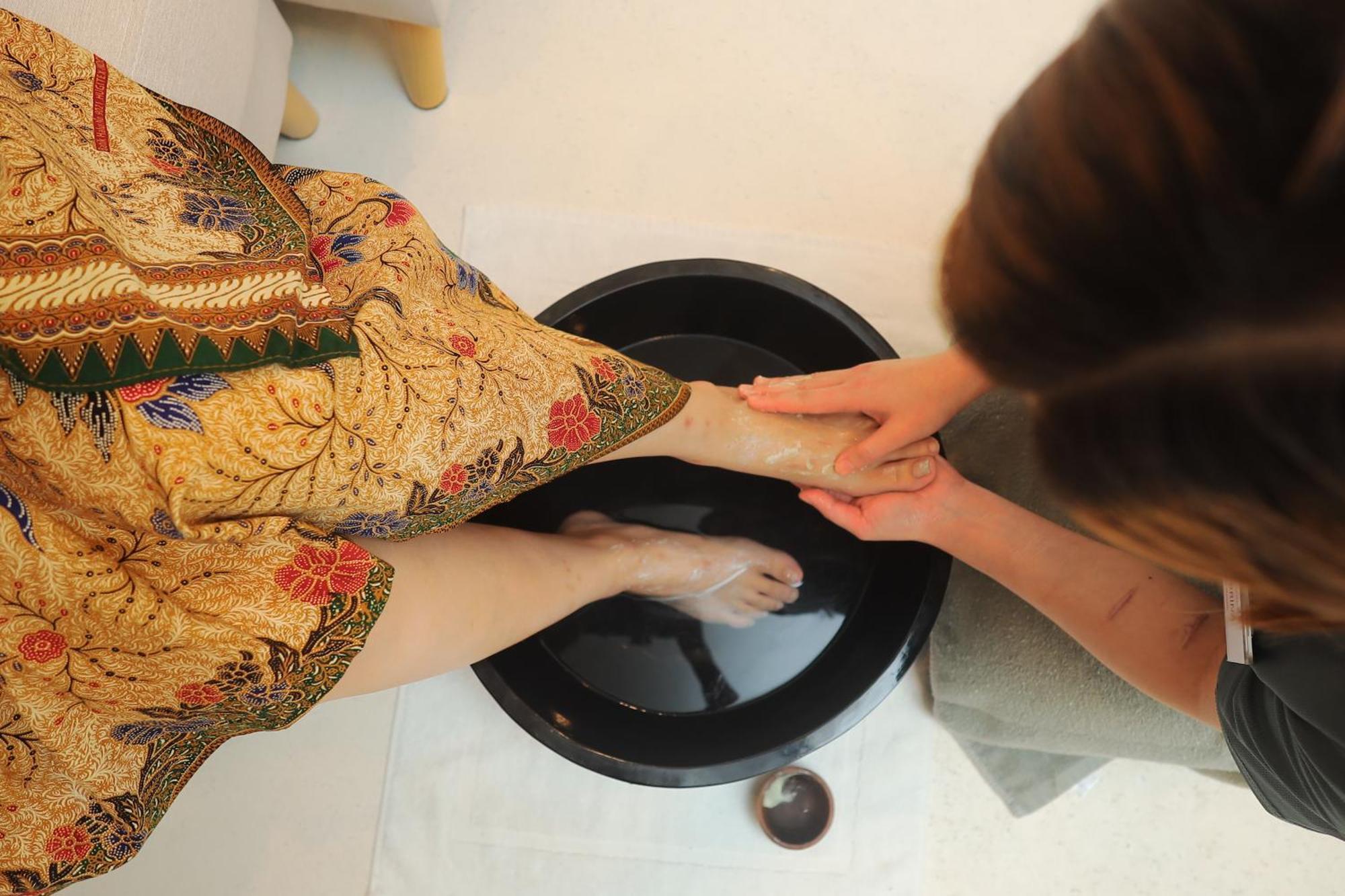 The Riyaz Lavanya Langkawi パンタイ・サナング エクステリア 写真 A woman washing the feet of a guest